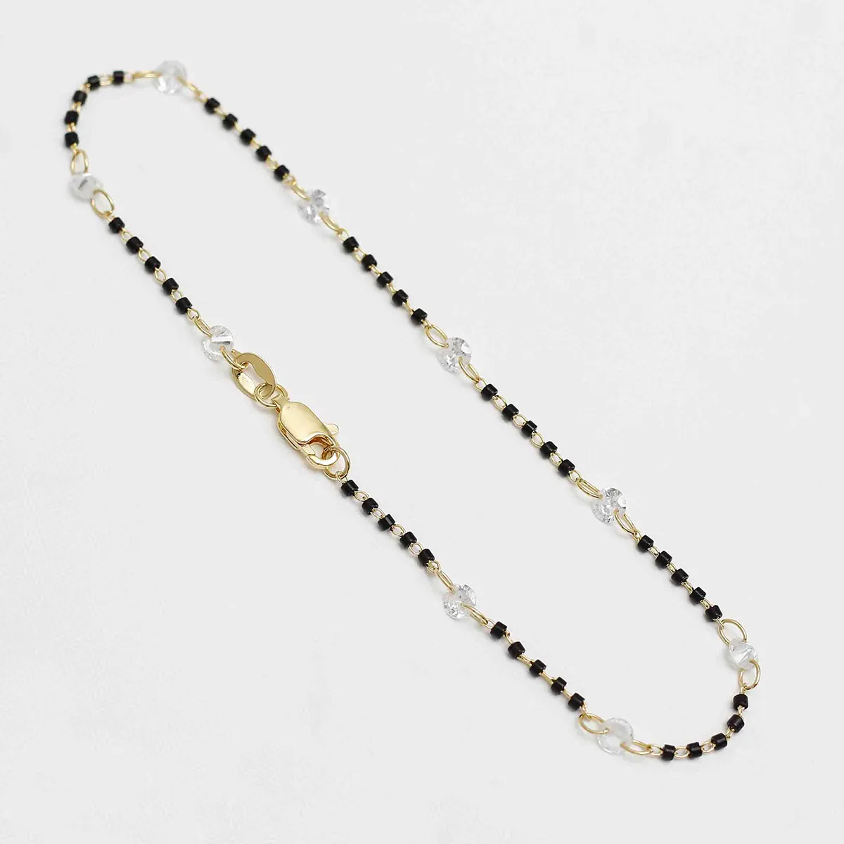 Tobillera Circonia Bicolor - cuentas negras y transparentes